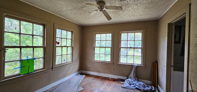 unfurnished sunroom with a healthy amount of sunlight and ceiling fan