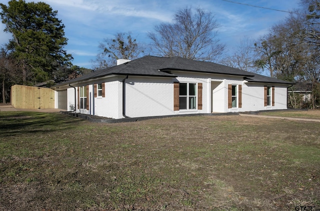 411 W Heritage Dr, Tyler, TX 75703 - back of house featuring brick siding, a lawn, a gate, and a chimney