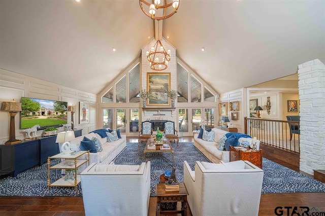 273 Fm 2276, Kilgore, TX 75662 - living room featuring wood-type flooring, an inviting chandelier, a decorative wall, a fireplace, and high vaulted ceiling