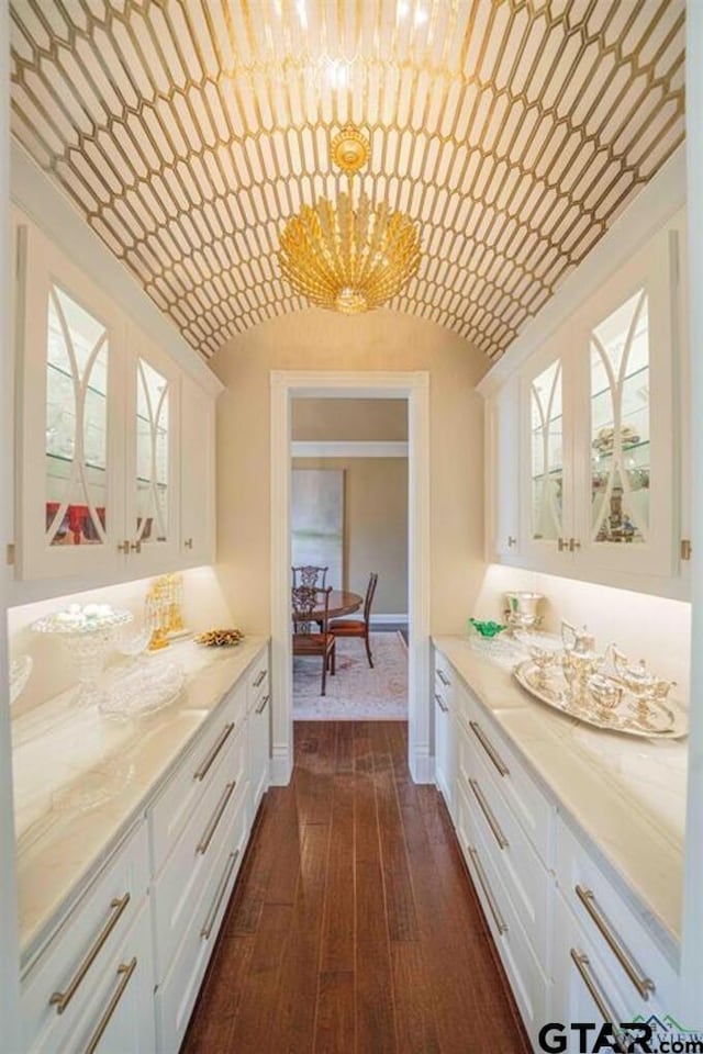 273 Fm 2276, Kilgore, TX 75662 - interior space featuring white cabinets, dark wood-style flooring, a notable chandelier, baseboards, and glass insert cabinets
