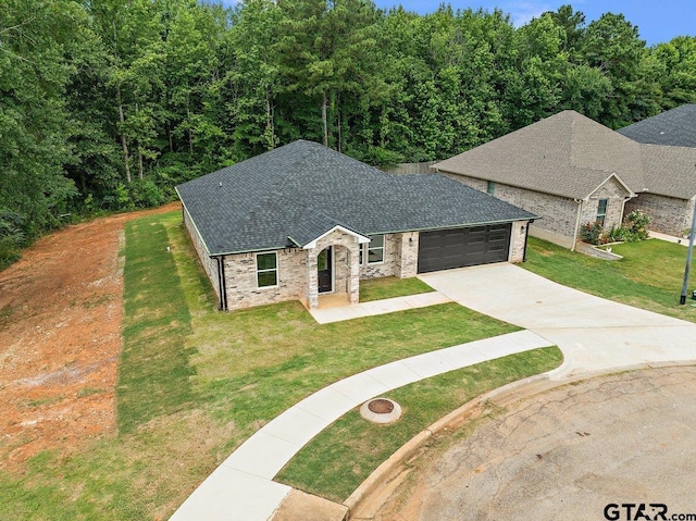 437 Tara Ln, Troup, TX 75789 - view of front of house with driveway, roof with shingles, a front lawn, an attached garage, and brick siding