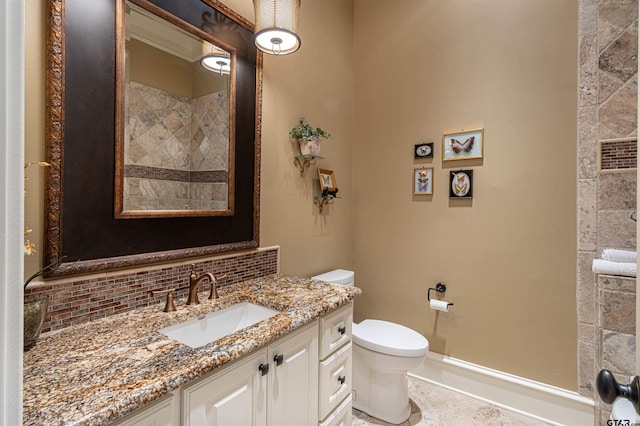 bathroom with backsplash, toilet, and vanity