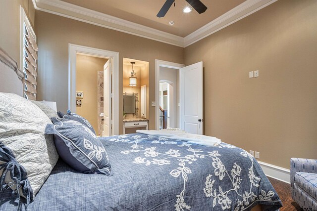 bedroom featuring ceiling fan, crown molding, and ensuite bath