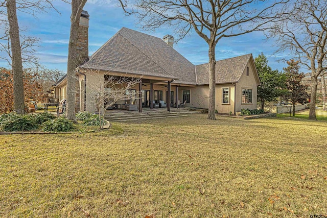 rear view of house with a patio area and a lawn