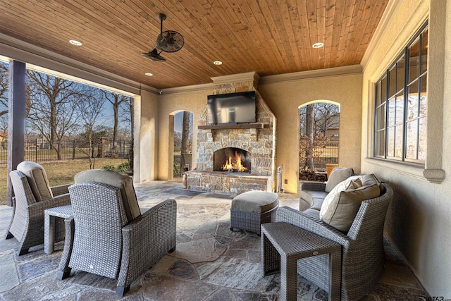 view of patio / terrace with ceiling fan and an outdoor stone fireplace