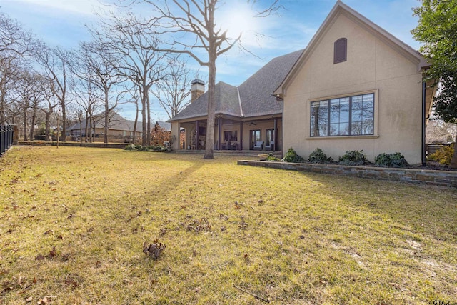 rear view of house featuring a lawn