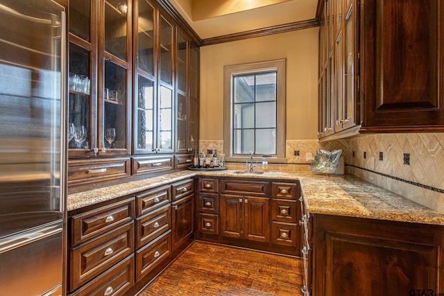 kitchen featuring sink, backsplash, high end fridge, light stone countertops, and dark hardwood / wood-style floors