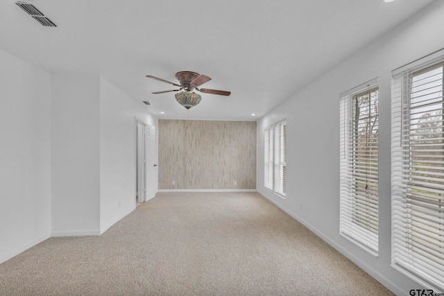 spare room with ceiling fan and light carpet