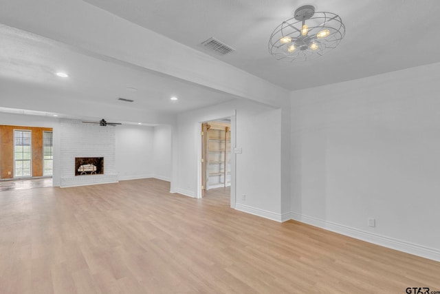 unfurnished living room featuring a fireplace, light hardwood / wood-style flooring, and ceiling fan