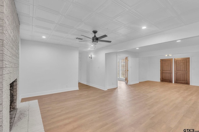 unfurnished living room with ceiling fan, light wood-type flooring, and a fireplace