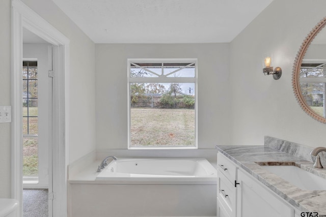 bathroom with vanity, a tub to relax in, and a wealth of natural light