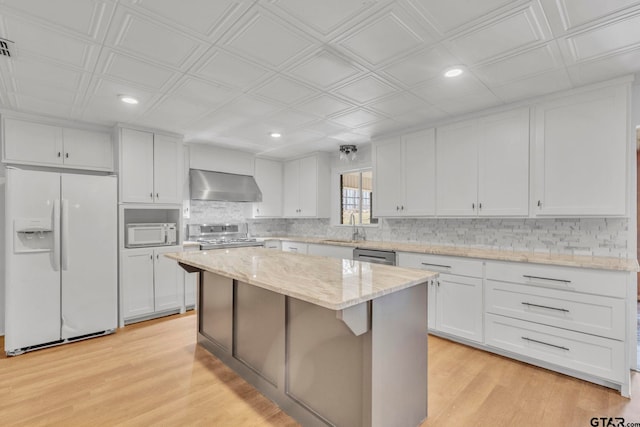 kitchen featuring white cabinetry, light hardwood / wood-style flooring, wall chimney exhaust hood, and appliances with stainless steel finishes