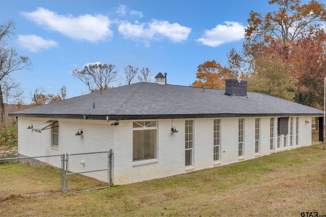 rear view of house featuring a yard