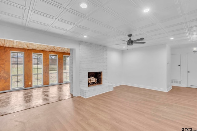 unfurnished living room featuring light wood-type flooring, a brick fireplace, and ceiling fan