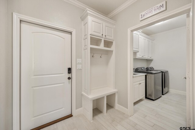 mudroom with light hardwood / wood-style floors, washing machine and dryer, and ornamental molding