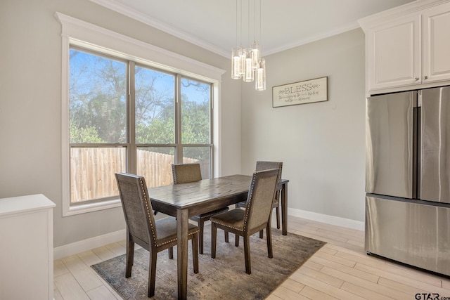 dining space featuring a chandelier, a healthy amount of sunlight, and ornamental molding