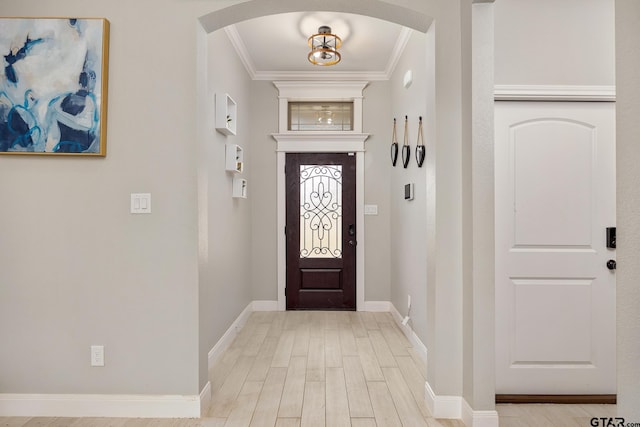 foyer with crown molding and light hardwood / wood-style floors