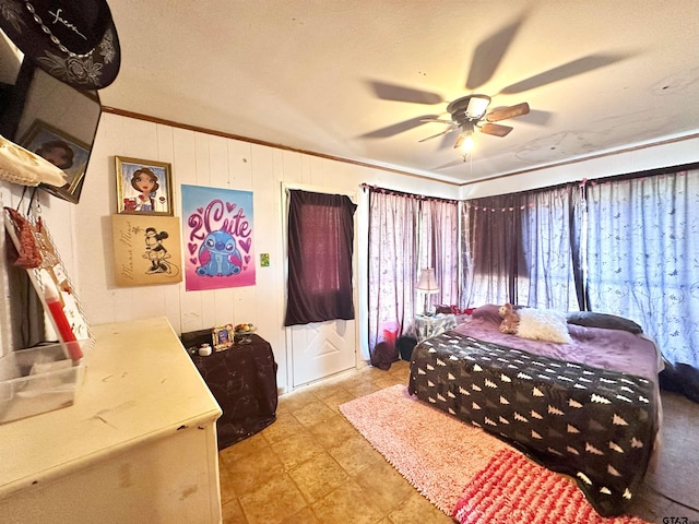 bedroom featuring wood walls, a textured ceiling, ceiling fan, and crown molding