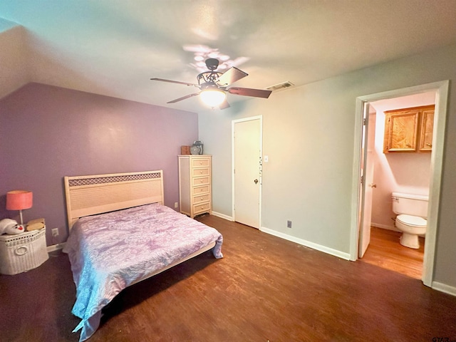 bedroom with dark wood-type flooring, vaulted ceiling, ceiling fan, and ensuite bathroom