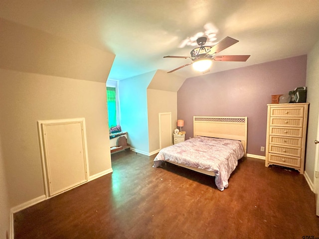 bedroom with dark wood-type flooring, vaulted ceiling, and ceiling fan