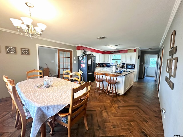 dining room with dark parquet floors, an inviting chandelier, and crown molding