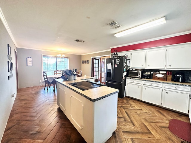 kitchen with black appliances, white cabinetry, parquet floors, and crown molding