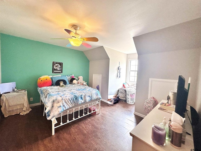 bedroom with a textured ceiling, dark hardwood / wood-style flooring, lofted ceiling, and ceiling fan