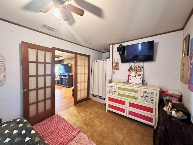 bedroom with french doors, hardwood / wood-style floors, ceiling fan, and crown molding