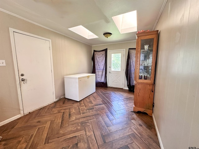 interior space featuring dark parquet floors, wooden walls, a skylight, and ornamental molding