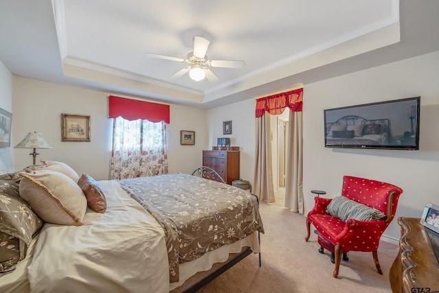 carpeted bedroom featuring crown molding, ceiling fan, and a raised ceiling