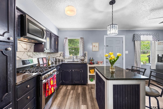 412 W 25th St, Tyler, TX 75702 - kitchen with stainless steel appliances, a textured ceiling, dark wood-style floors, plenty of natural light, and backsplash
