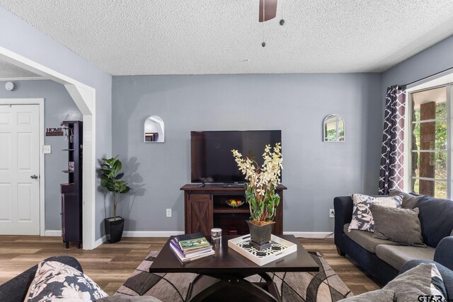 412 W 25th St, Tyler, TX 75702 - living area with wood finished floors, a textured ceiling, and a ceiling fan
