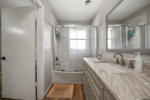 bathroom with shower / bath combination with glass door, wood-type flooring, and vanity