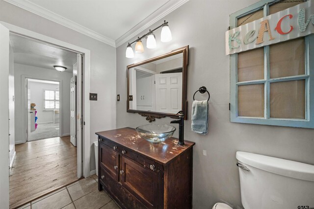 bathroom featuring vanity, hardwood / wood-style flooring, toilet, and ornamental molding