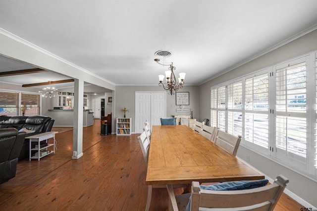 dining area featuring dark hardwood / wood-style flooring, crown molding, and a notable chandelier