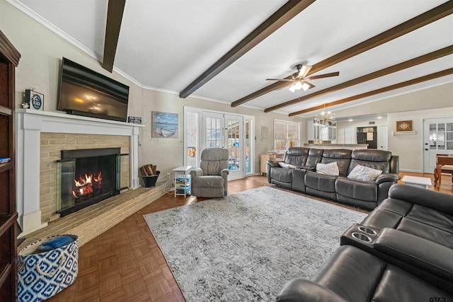 living room with dark parquet flooring, ceiling fan with notable chandelier, crown molding, lofted ceiling with beams, and a fireplace