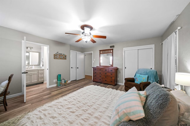 bedroom with ceiling fan, light wood-type flooring, sink, and ensuite bath