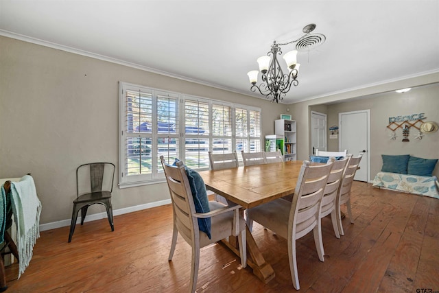 dining space featuring a chandelier, ornamental molding, and hardwood / wood-style flooring