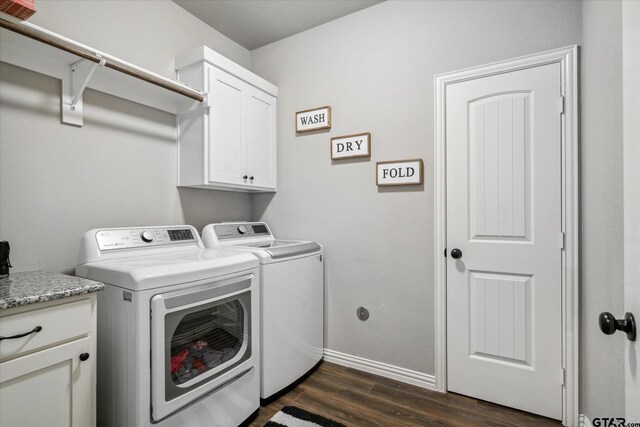 washroom featuring baseboards, washing machine and clothes dryer, cabinet space, and dark wood-style flooring