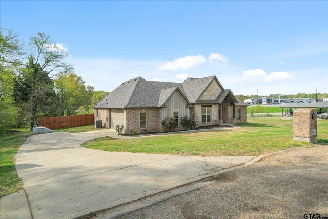 view of front of house featuring concrete driveway, fence, board and batten siding, a front yard, and brick siding