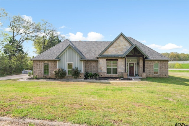 craftsman-style house with a front lawn, brick siding, board and batten siding, and roof with shingles