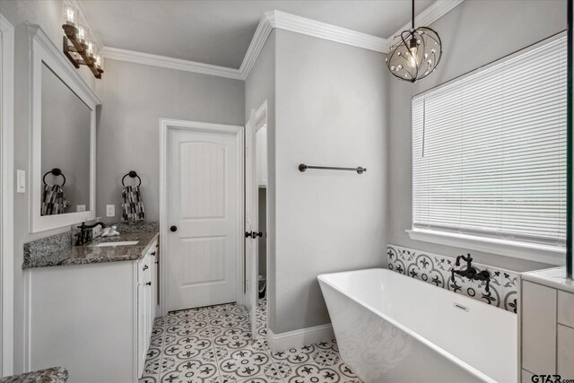 bathroom with vanity, a freestanding tub, ornamental molding, tile patterned floors, and a notable chandelier