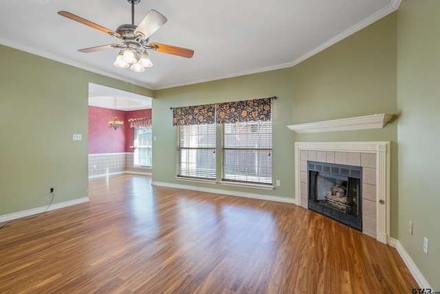 unfurnished living room featuring hardwood / wood-style floors, ceiling fan with notable chandelier, crown molding, and a fireplace