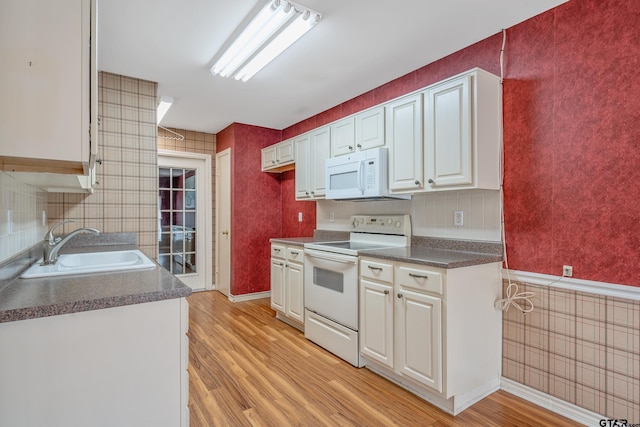 kitchen featuring light hardwood / wood-style floors, white cabinetry, white appliances, and sink