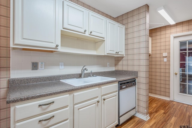 kitchen featuring white dishwasher, light wood-type flooring, white cabinetry, and sink