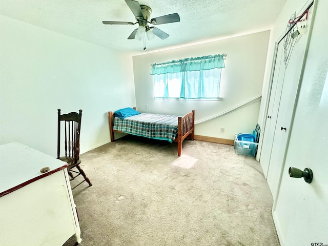 bedroom featuring a textured ceiling, carpet flooring, a ceiling fan, and baseboards