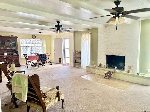 living area featuring ceiling fan, beamed ceiling, carpet, a textured ceiling, and a fireplace