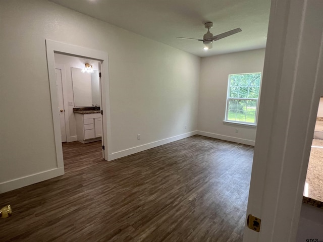180 Lovers Ln, Alto, TX 75925 - unfurnished bedroom with dark wood-style flooring, ensuite bathroom, and a ceiling fan