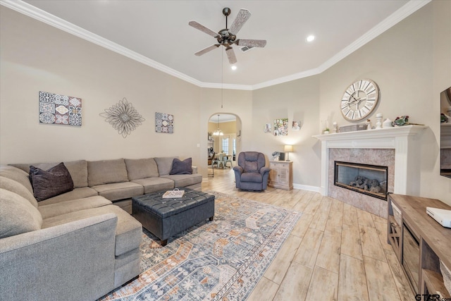 3109 Granbury Ct, Tyler, TX 75707 - living room with ceiling fan, wood finished floors, arched walkways, a tile fireplace, and crown molding