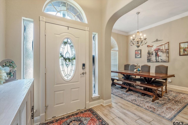 3109 Granbury Ct, Tyler, TX 75707 - entrance foyer with a chandelier, arched walkways, light wood-style flooring, and ornamental molding